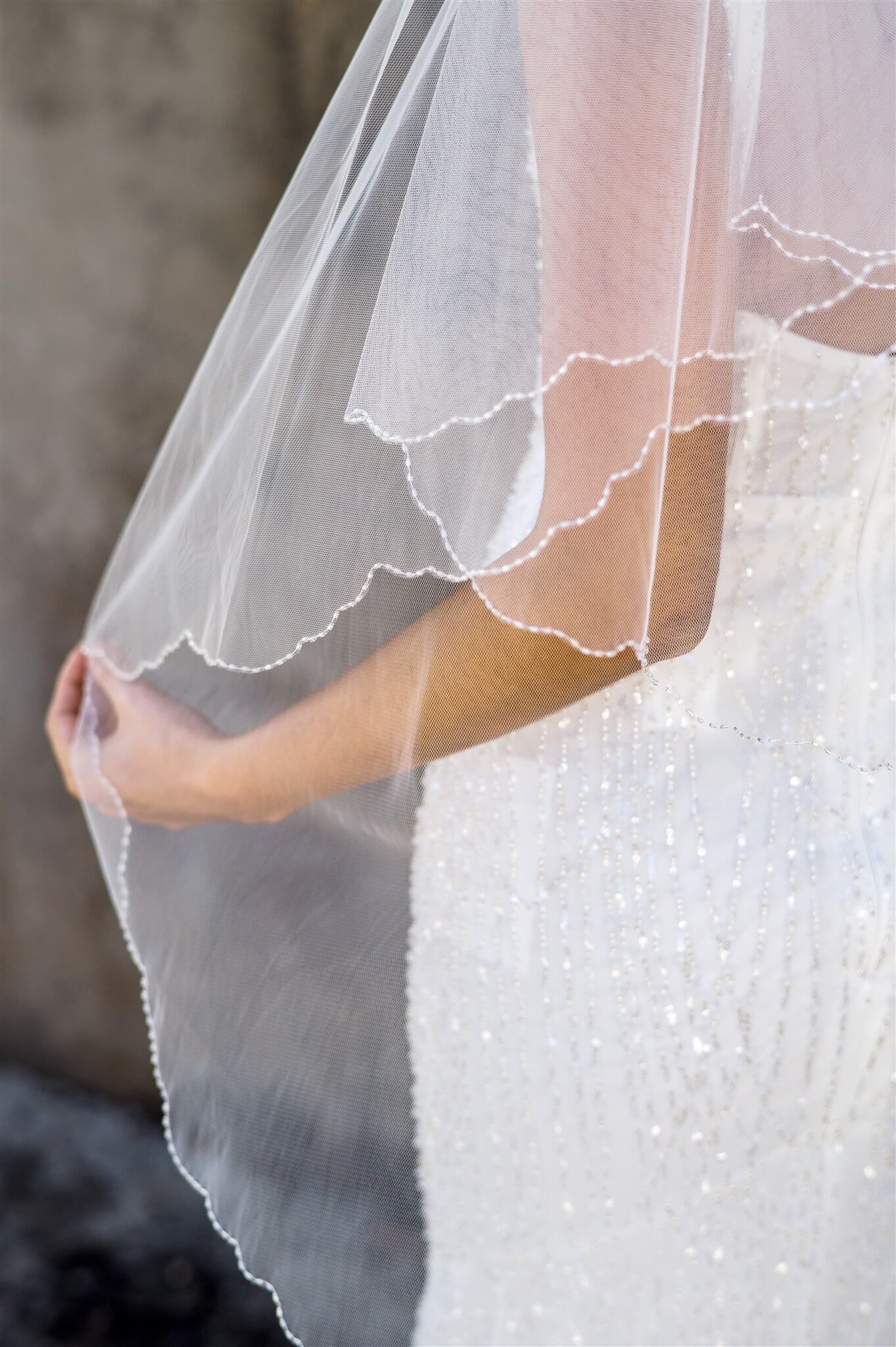 Close-up of a wedding dress with a veil, focusing on the details.