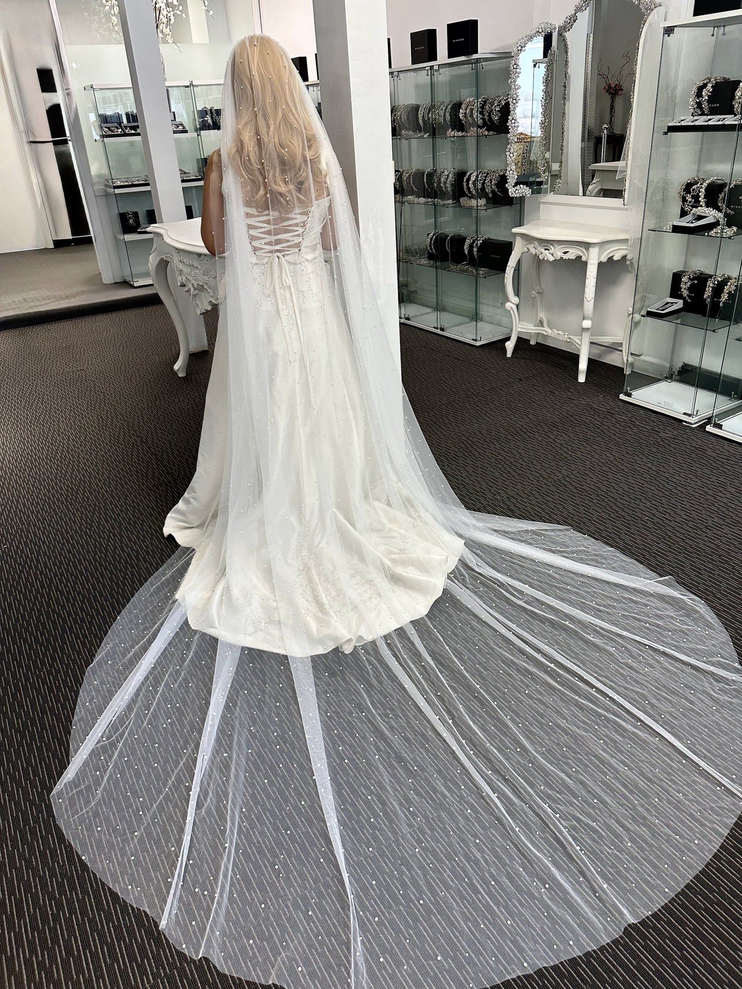 White wedding dress with a long train in a store setting